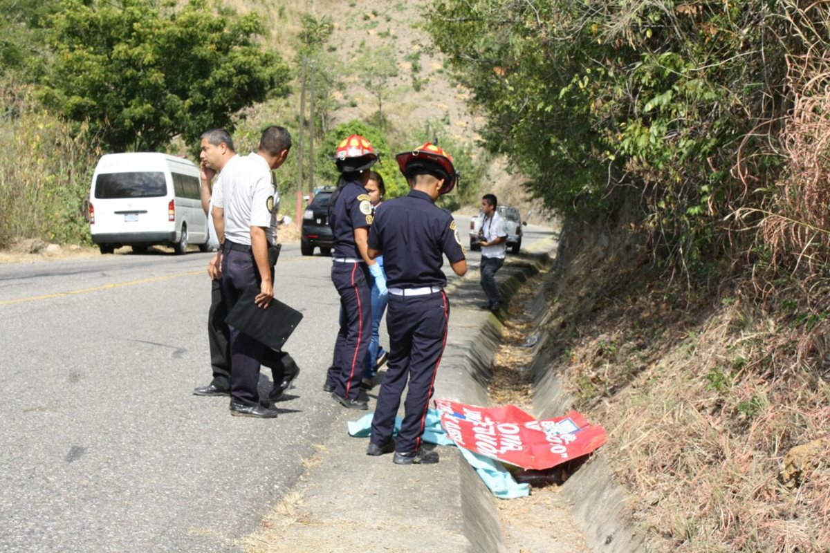 Socorristas observan el cadáver de un trabajador de Covial que fue arrollado en Sansare, El Progreso. (Foto Prensa Libre: Héctor Contreras)
