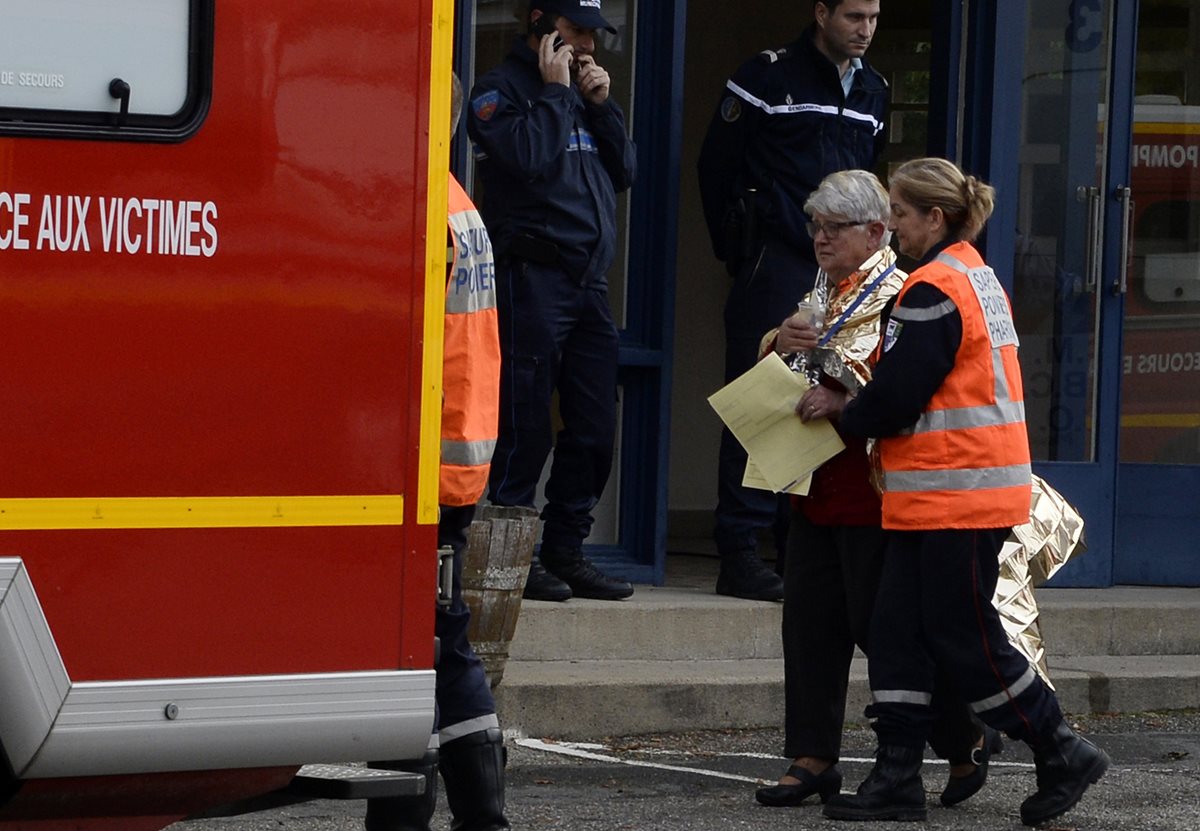 Una mujer es trasladada a una ambulancia después del mortal accidente en Francia. (Foto Prensa Libre: AFP).