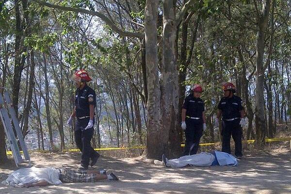 Bomberos cubren los cadáveres a la espera del MP. (Foto Prensa Libre: Jerson Ramos)<br _mce_bogus="1"/>