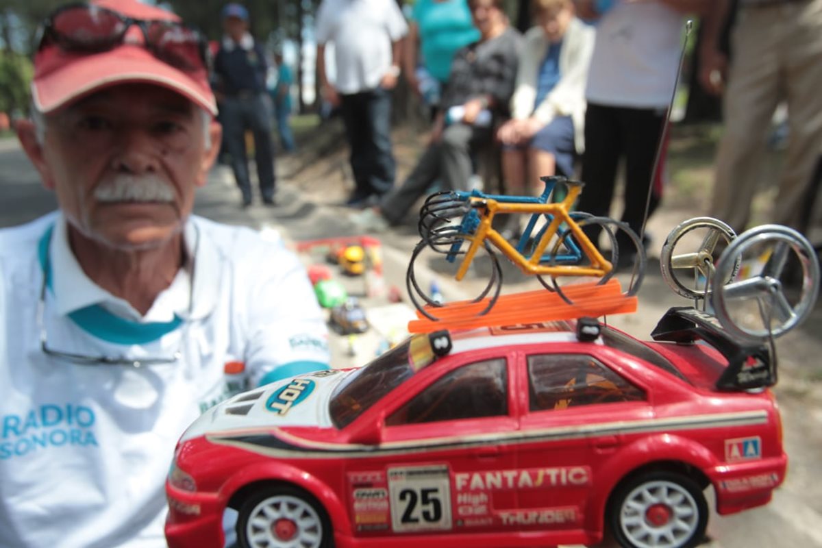 El señor Pineda Spillari muestra uno de los vehículos que lleva en el techo una bicicleta. (Foto Prensa Libre: Norvin Mendoza)