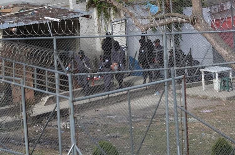 Guardias penitenciarios retiran cuerpos de pandilleros asesinados. (Foto Prensa Libre: Hemeroteca)