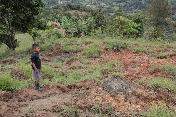 UN  niño observa la grieta formada en un cerro cercano a  su comunidad.