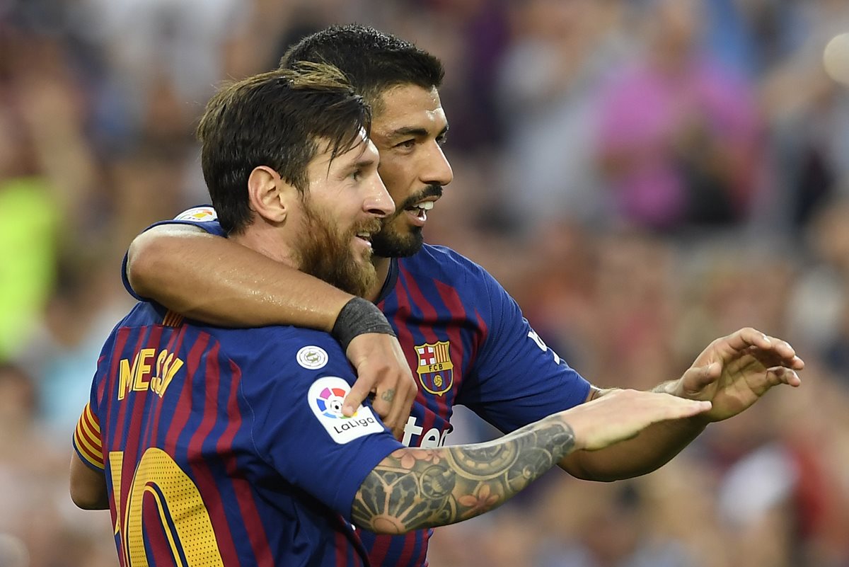 Lionel Messi celebra junto a Luis Suárez. La dupla del Barcelona fue clave en la goleada frente al Huesca. (Foto Prensa Libre: AFP)