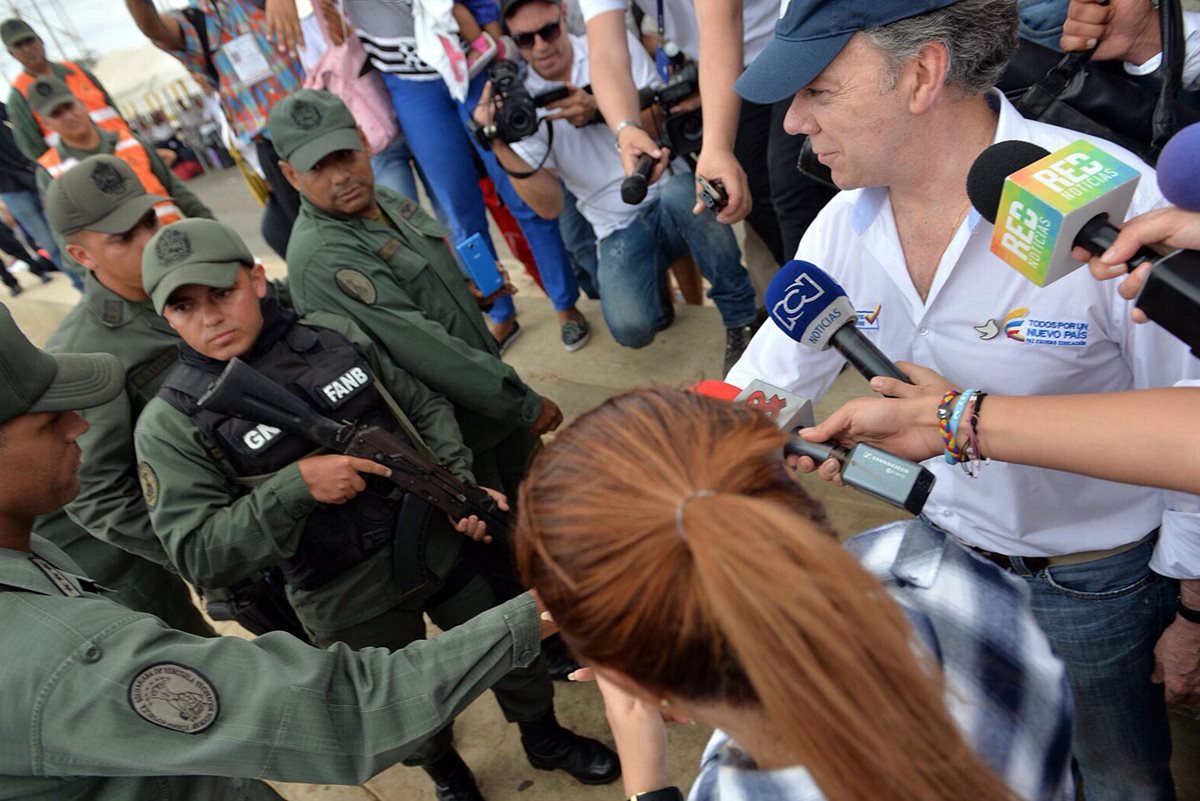El presidente de Colombia, Juan Manuel Santos (derecha), saluda a un guardia de las fuerzas armadas de Venezuela, durante la visita que hizo a la frontera. (Foto Prensa Libre: EFE).