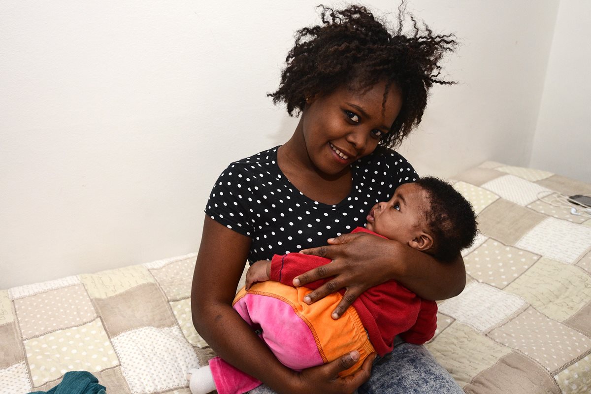 Francesca descansa en los brazos de su madre, Stephanie, que sonríe, sabe que se siente segura en Italia. (Foto Prensa Libre: AFP).