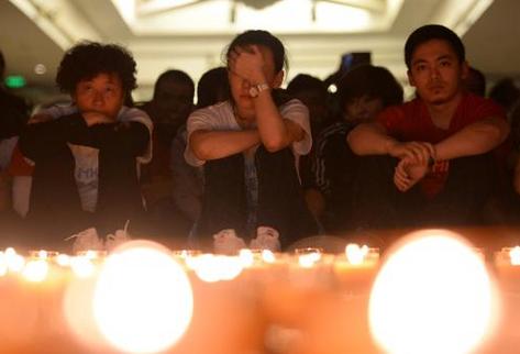 Familiares de pasajeros del avión de Malaysia Airlines desaparecido el 8 de marzo participan en una vigilia. (Foto Prensa Libre: AFP).
