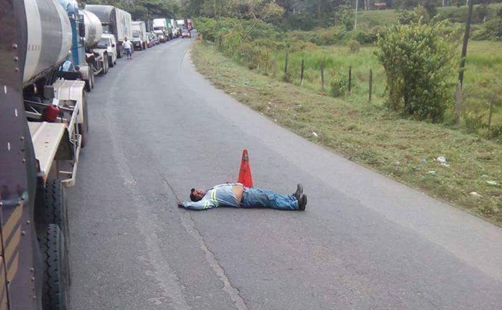 Santiago Morán permanece tirado en el asfalto para evitar que vehículos rebasen. (Foto Prensa Libre: Cortesía).