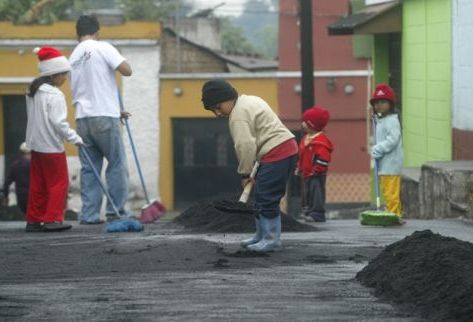 Adultos y pequeños se dan a la tarea de retirar la arena volcánica lanzada por la erupción del Pacaya. (Foto Prensa Libre: Erick Ávila)
