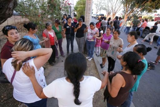 La gente reza frente a la iglesia donde el sacerdote Juan Miguel Contreras donde murió. (Foto Prensa Libre: AFP)