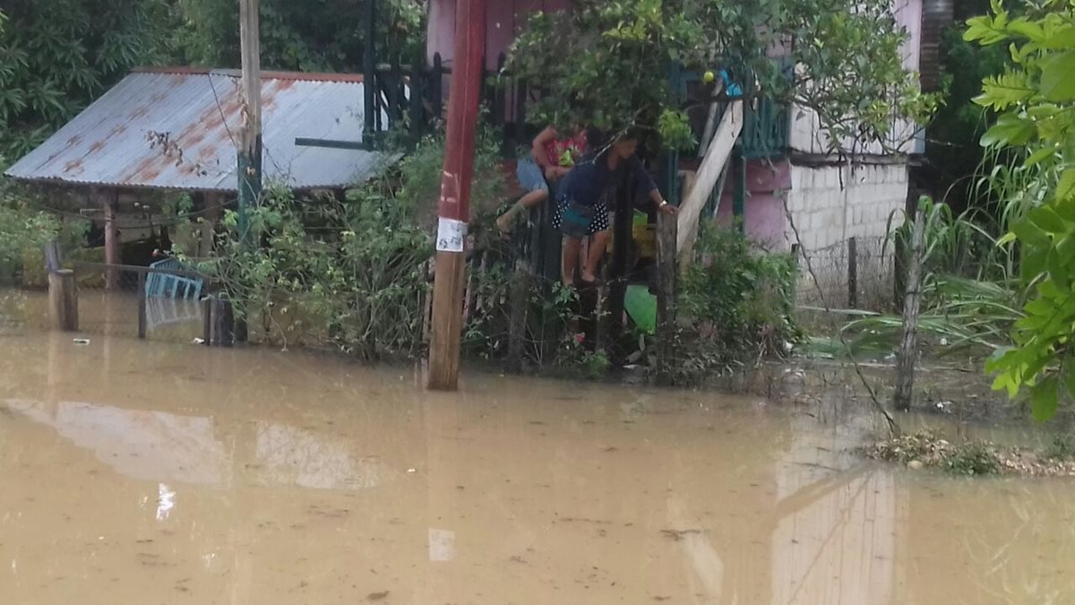 Un grupo de personas se pone a salvo en una comunidad de Petén, donde las lluvias de las últimas horas causaron daños en varias viviendas. (Foto Prensa Libre: Conred)