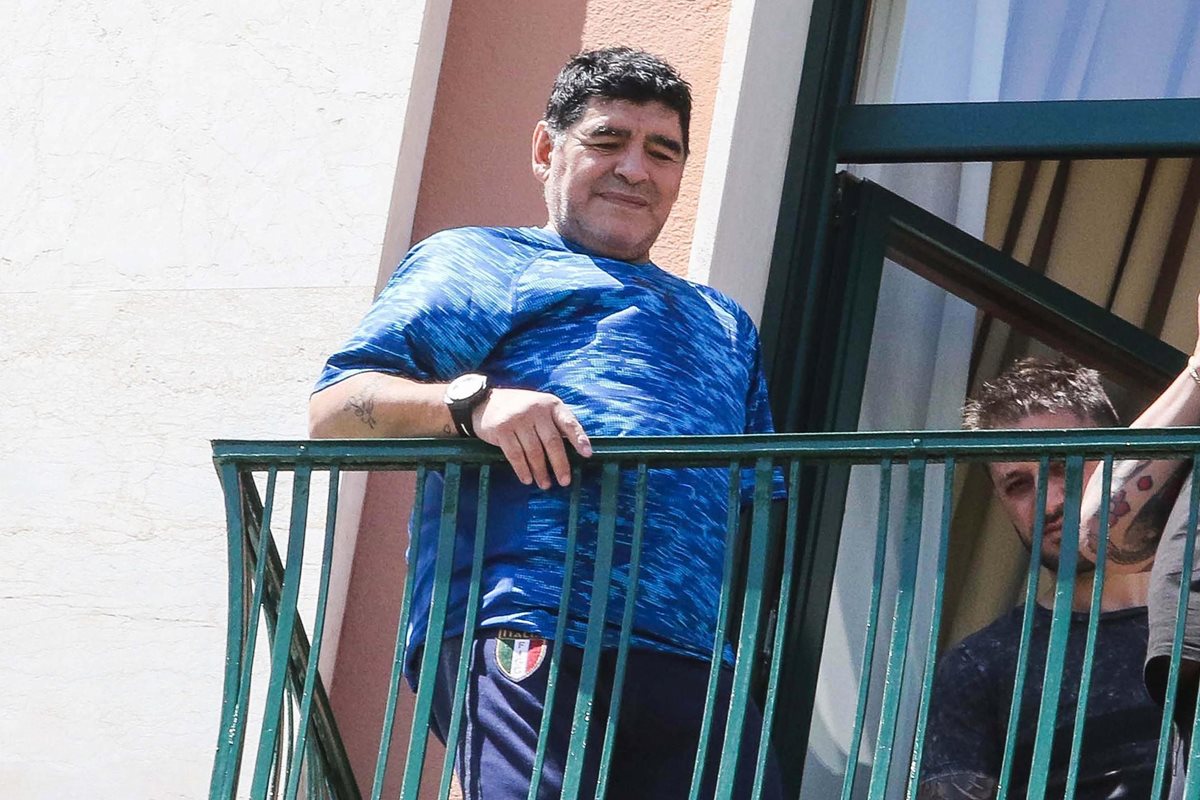Diego Maradona saluda a sus seguidores desde la ventana del hotel en Nápoles. (Foto Prensa Libre: EFE)