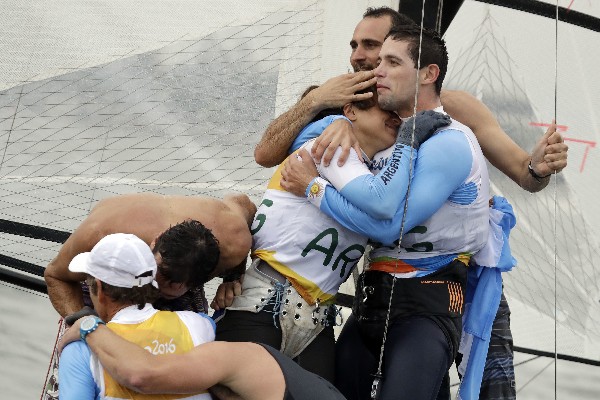 Atletas argentinos festejan la medalla de oro conseguida por Santiago Lange. (Foto Prensa Libre: AFP).
