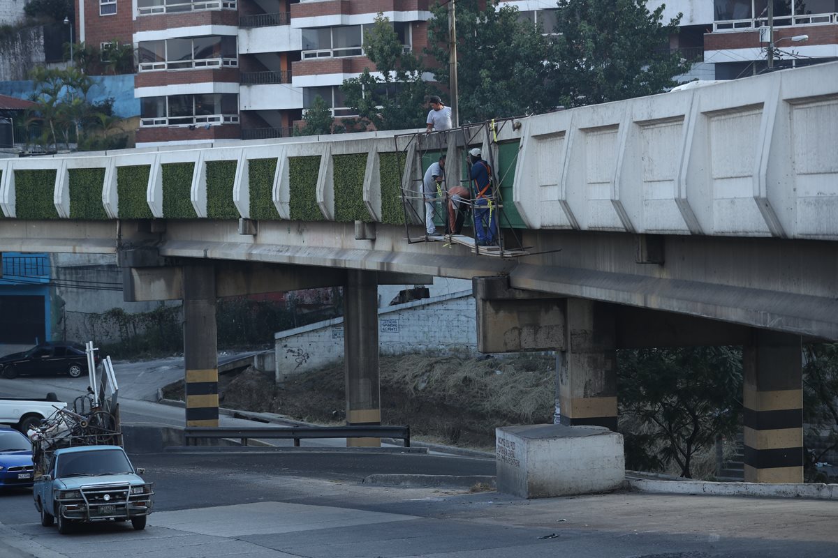 Remozamiento del  puente El Caminero, ubicando entre la zona 6 y 7. Una empresa coloca gramilla sintética en los costados. (Foto Prensa Libre: Esbin García)