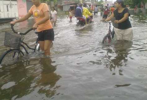 Vecinos del puerto San José tratan de incorporarse a sus actividades pese a las inundaciones (Foto Prensa Libre: Teaser/Velmax)