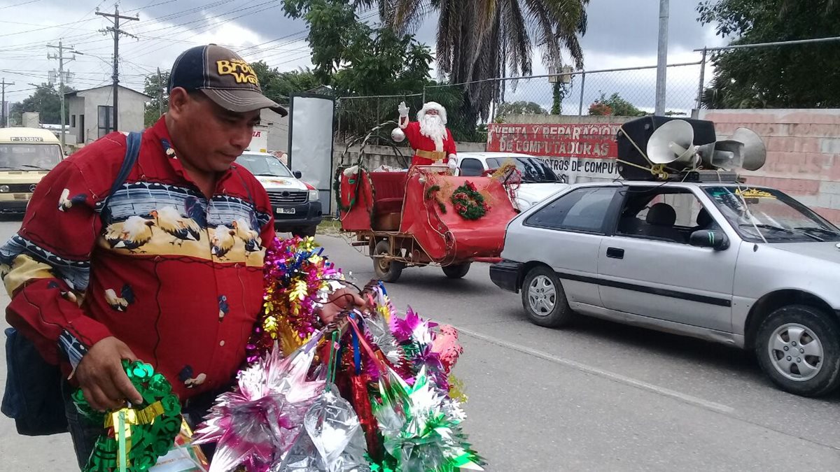 Santa Claus recorre calle de San Benito para llevar un mensaje de alegría a los niños y adultos. (Foto Prensa Libre: Rigoberto Escobar).
