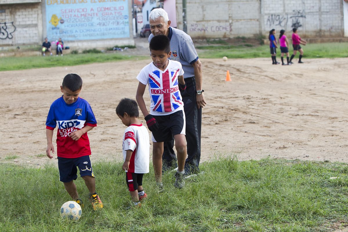Hernán Mateo, de siete años, (izquierda) entrena en la colonia Sakerty de la zona 7, con la Fundación Rojos del 74. José Manuel Contreras le regaló zapatos de futbol. (Foto Prensa Libre: Norvin Mendoza)