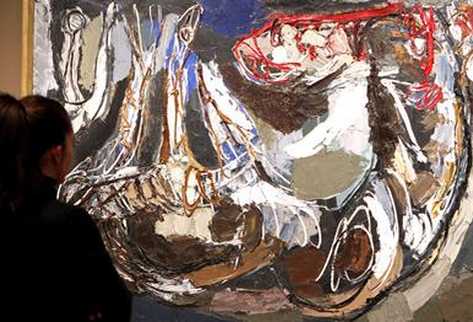 Una mujer aprecia una de las cuatro series de grabados más importantes de Goya. (Foto Prensa Libre: EFE)