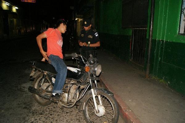 un Agente     solicita los documentos a  piloto de motocicleta.