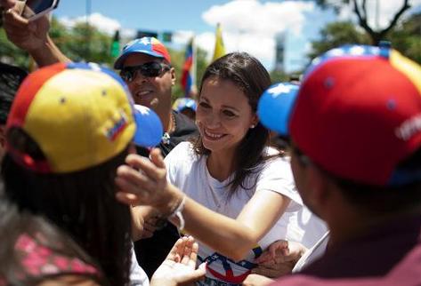 La diputada opositora venezolana María Corina Machado (C), destituida por el oficialismo, saluda a simpatizantes. (Foto Prensa Libre: AFP).