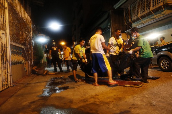 Policías trasladan a una de las víctimas asesinadas en Manila,Filipinas.(Foto Prensa Libre:EFE)