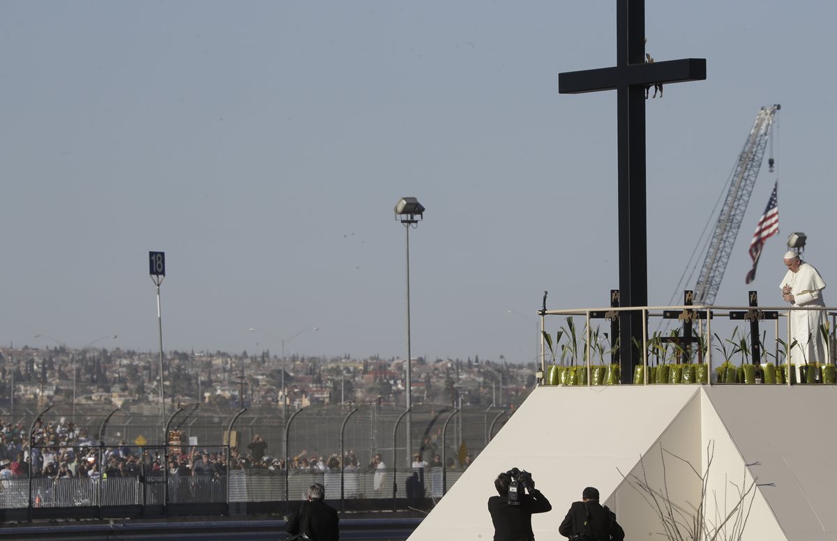El papa Francisco, frente a una cruz eregida en homenaje a los migrantes muertos. (Foto Prensa Libre: AP).