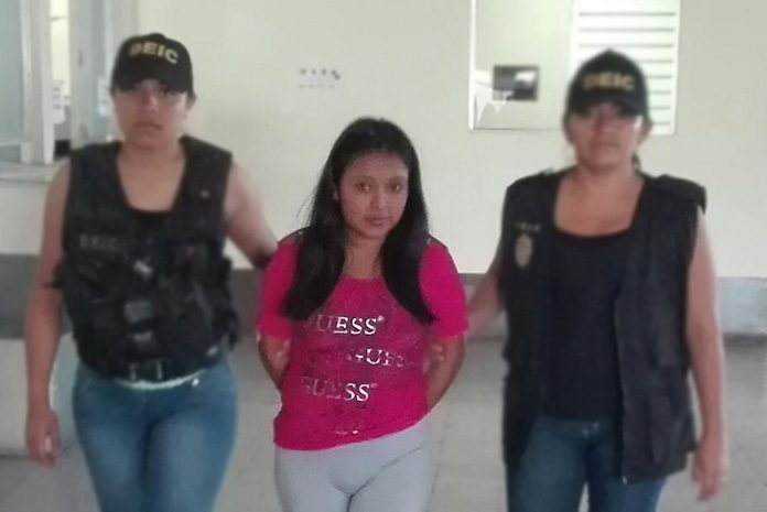 Adriana Pérez Gómez es conducida por agentes de la DEIC por parricidio en grado de tentativa y maltrato a menores. (Foto Prensa Libre: PNC)