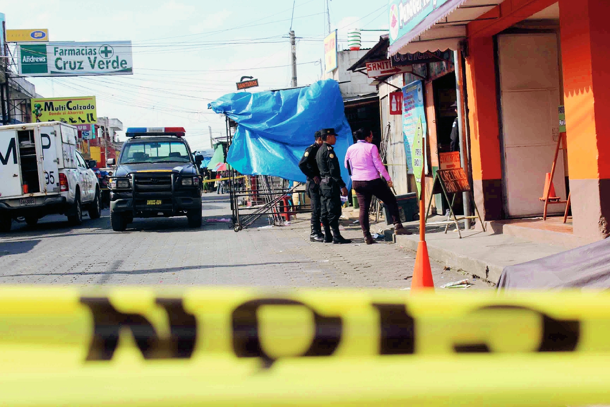 Agentes de la PNC acordonan área donde fue muerto a balazos un hombre, en una cevichería de Chimaltenango. (Foto Prensa Libre: José Rosales)
