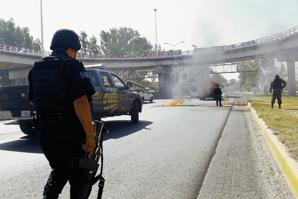 Los delincuentes quemaron simultáneamente varios vehículos robados para bloquear accesos a Guadalajara. (Foto Prensa Libre:AFP)AFP
