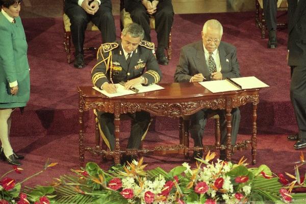 Pérez Molina  suscribe el Acuerdo de Paz Firme y Duradera, junto       a Carlos González, uno de los dirigentes de la URNG, el 29 de diciembre de 1996.