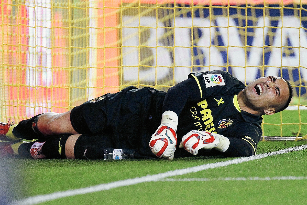 Sergio Asenjo se toma la rodilla luego de lesionarse en el partido frente al Atlético de Madrid. (Foto Prensa Libre: EFE)