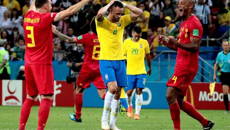 Vermaelen y Kompany celebran el pase a semifinales frente a la mirada perdida de Renato Augusto, autor del gol del descuento brasileño. (Foto Prensa Libre: EFE)