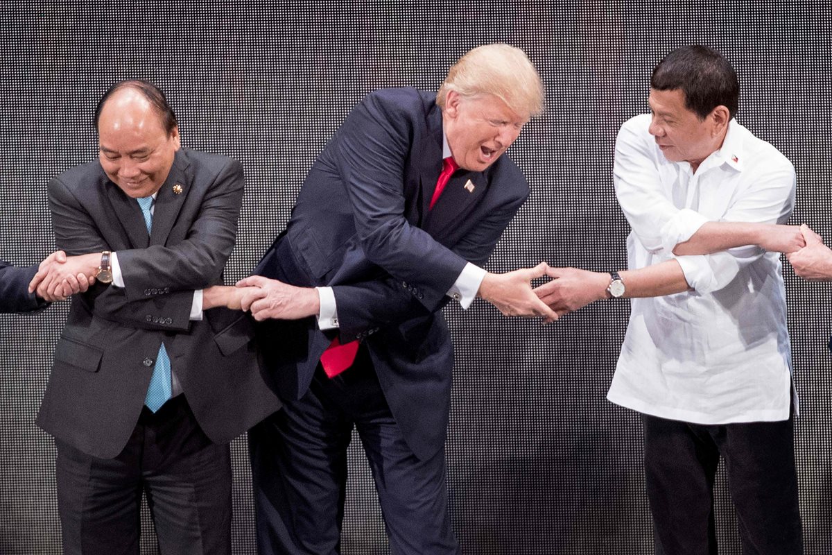 Trump -centro-, de gira por Asia, promueve sanciones contra Corea del Norte. (Foto Prensa Libre: AFP)