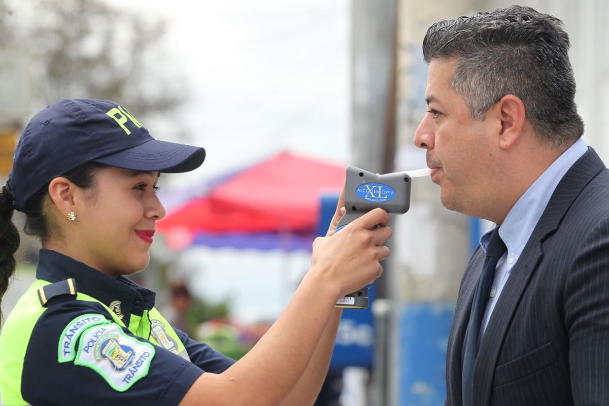 Una agente de la PMT de Mixco efectúa una prueba de alcoholemia a un conductor. (Foto Prensa Libre: Érick Ávila)