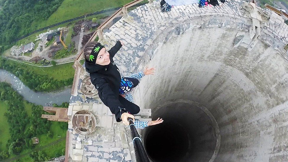Estos jóvenes arriesgaron su vida para tomarse este selfie en la cornisa de una chimenea de 180 metros de altura en desuso en Rumania. (Foto Prensa Libre:GETTY IMAGES)
