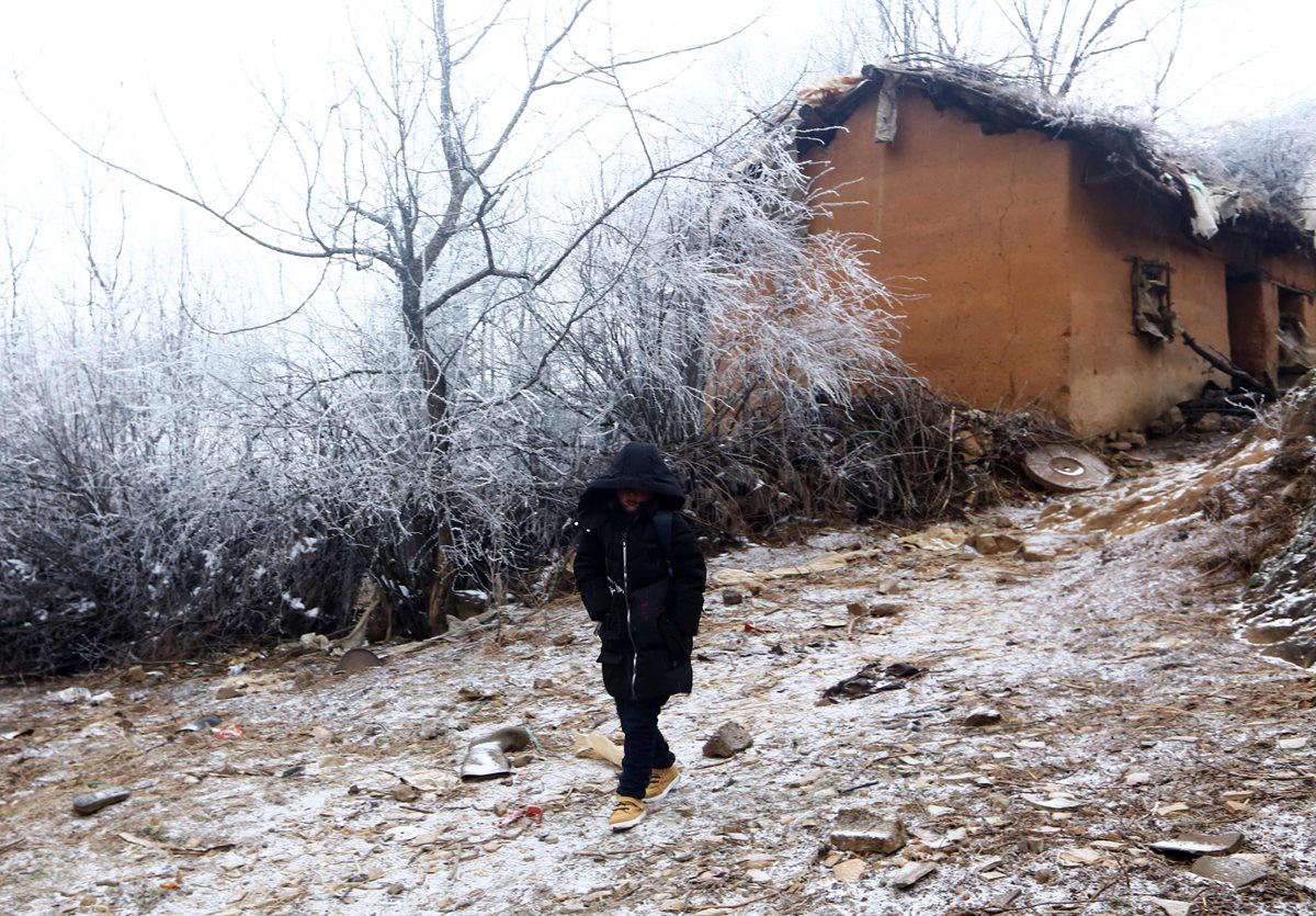 El niño Wang Fuman emprende el camino desde su choza hacia la escuela en Ludian, China. (Foto Prensa Libre: AFP)