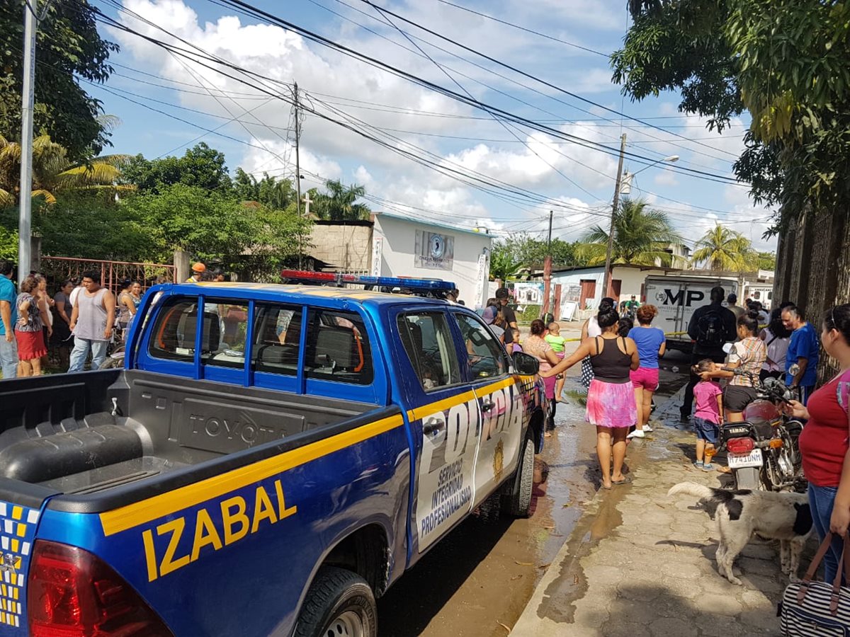 Curiosos permanecen en el lugar donde murió baleado Salvador Díaz Molina, en Puerto Barrios. (Foto Prensa Libre: Dony Stewart).