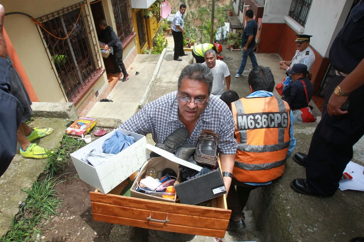 Vecinos de Tierra Nueva 1 evacuan el área por el riesgo de más derrumbes. (Foto Prensa Libre: Estuardo Paredes)