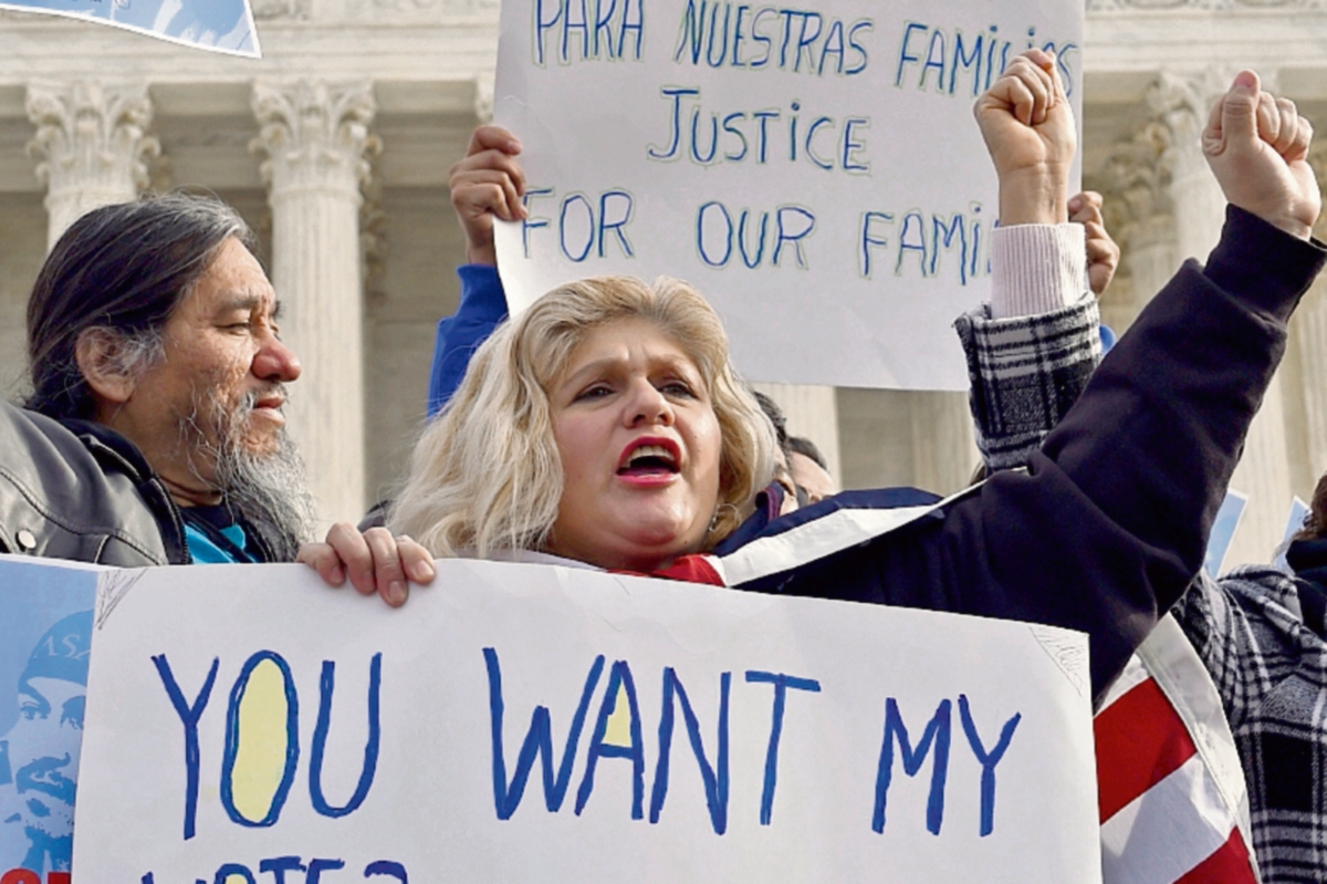 Activistas protestan en Estados Unidos contra las redadas que afectan a centroamericanos. (Foto Prensa Libre: AP)
