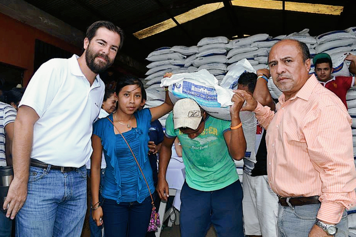 Ricardo Maldonado , alcalde de Chicacao, Suchitepéquez -a la izquierda- entrega fertilizantes a pobladores de ese municipio. (Foto Prensa Libre: )