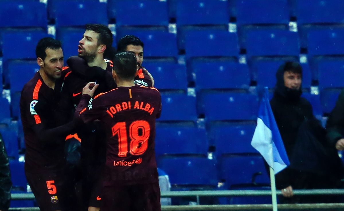 Gerard Piqué celebra junto a sus compañeros de equipo después de anotar el gol del empate contra el Espanyol. (Foto Prensa Libre: AFP)
