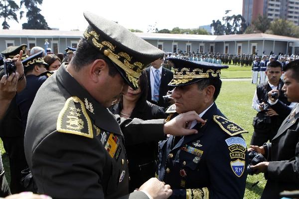 ULISES ANZUETO, ministro de la Defensa, coloca una insignia  a uno de los militares ascendidos.