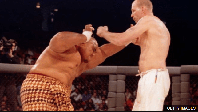 La primera pelea en la historia del UFC fue entre el holandés Gerard Gordeau y el luchado de sumo Teila Tuli. (Foto Prensa Libre: BBC News Mundo)