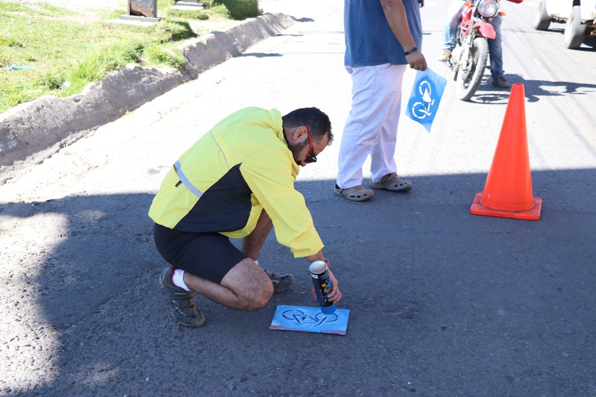 Voluntarios pintan bicicletas para marcar el camino adecuado que deben utilizar los ciclistas para viajar de La Esperanza a Xela.(Foto Prensa Libre: María José Longo)