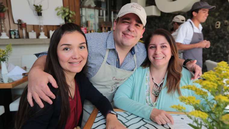 Ignacio Andrade, uno de los jóvenes que trabajan en Café Consciente, junto a dos clientas. (Foto Prensa Libre: Álvaro Interiano).