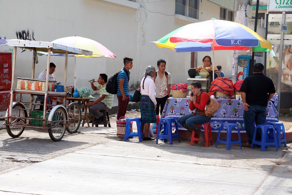 Vendedores de comida proliferan en las calles de la zona 3 de Xela, y se instalan incluso donde hay tragantes. (Foto Prensa Libre: Carlos Ventura)