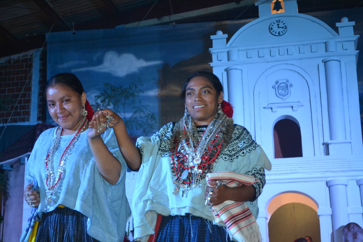 Yessica Eoliza Hun Chen, reina saliente, entrega la Cruz del Cristo Yacente de la Agonía a Dora Patricia Caal Ho, nueva Princesa Tezulutlán, en Cobán, Alta Verapaz. (Foto Prensa Libre: Ángel Martín Tax)