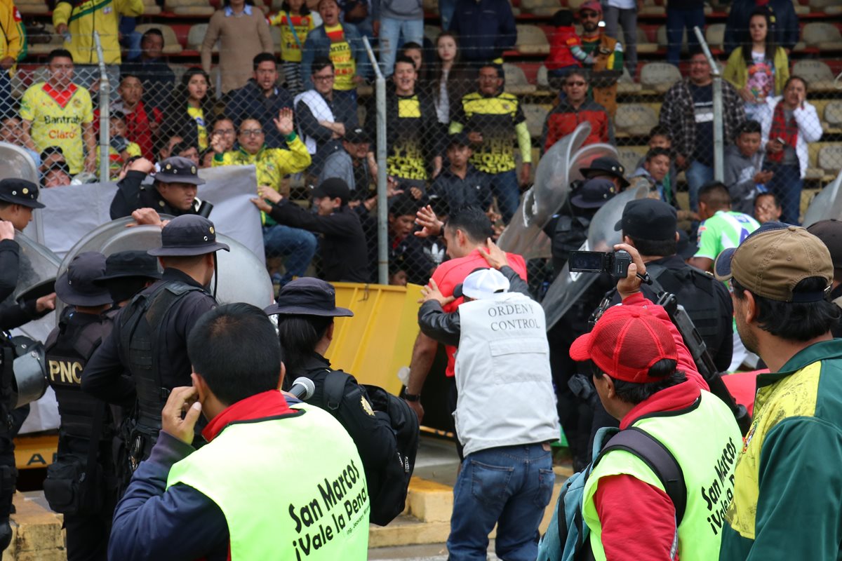 La cuarteta arbitral ingresa a los camerinos custodiada por las fuerzas de seguridad. (Foto Prensa Libre: Raúl Juárez)