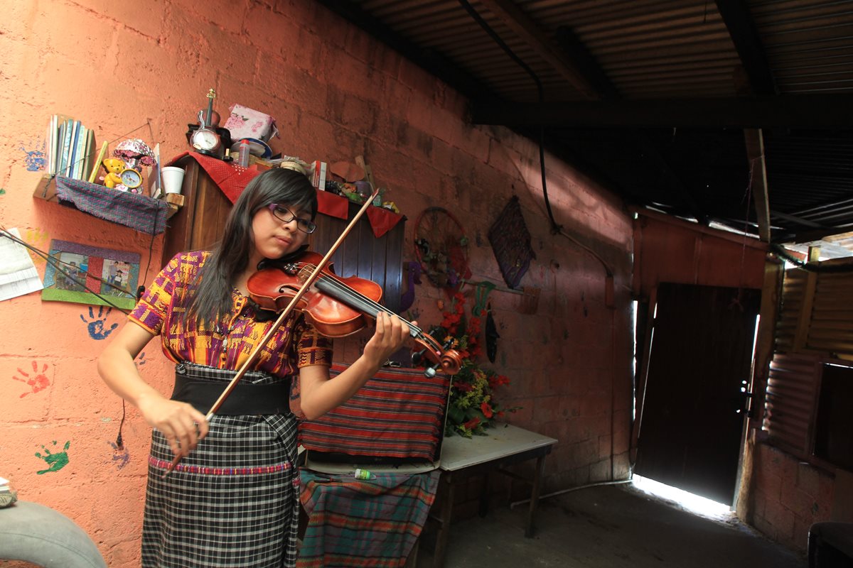 La maestra Isabel Patzán practica el violín en su vivienda antes de impartir clases privadas en comunidades de San Juan Sacatepéquez. (Foto Prensa Libre: Esbin García)