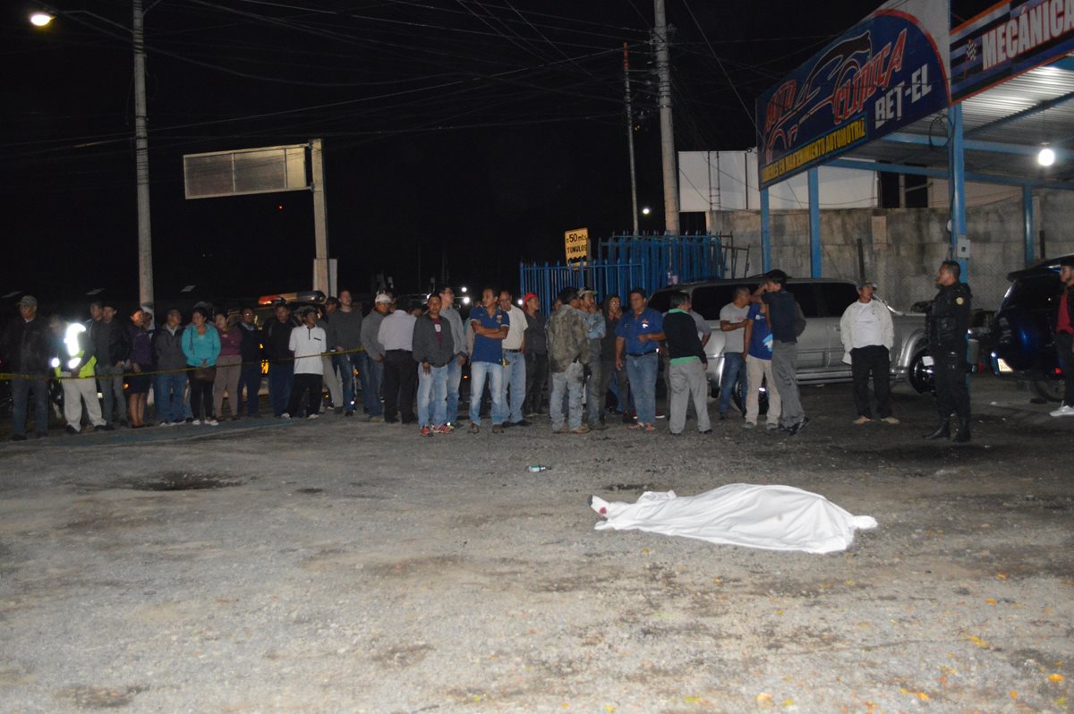 Curiosos se reúnen en el área donde fue ultimado Joel Recinos Martínez, en la ciudad de Huehuetenango. (Foto Prensa Libre: Mike Castillo).