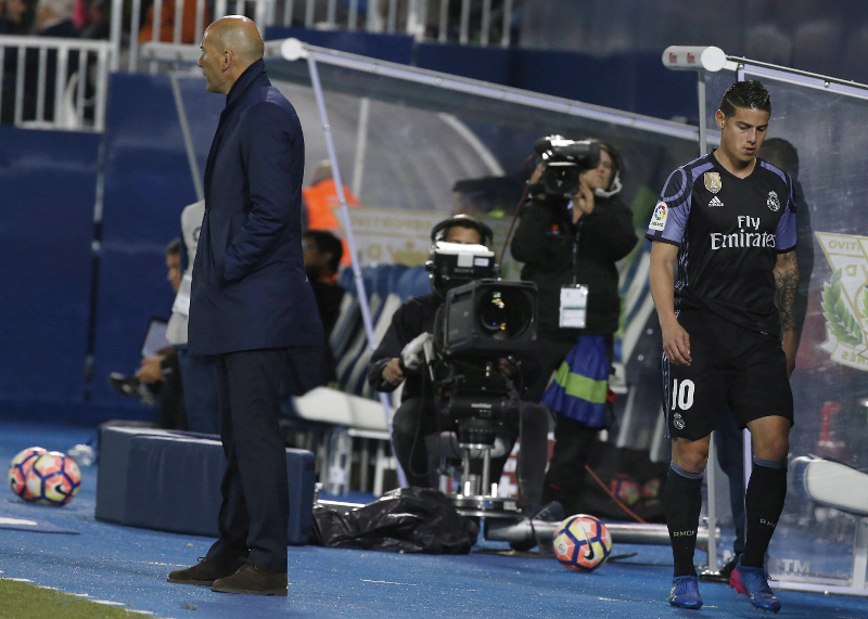 James Rodríguez sale molesto del estadio por el cambio. Observa a su entrenador, Zinedine Zidane. (Foto Prensa Libre: EFE)